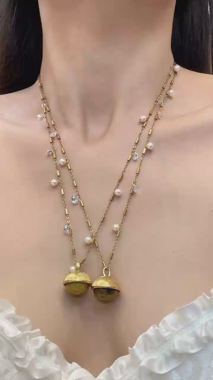 Video cover of model wearing gold shell pendant station necklace with scattered pearl and zircon beads in 316L stainless steel by Miduoduo Jewelry