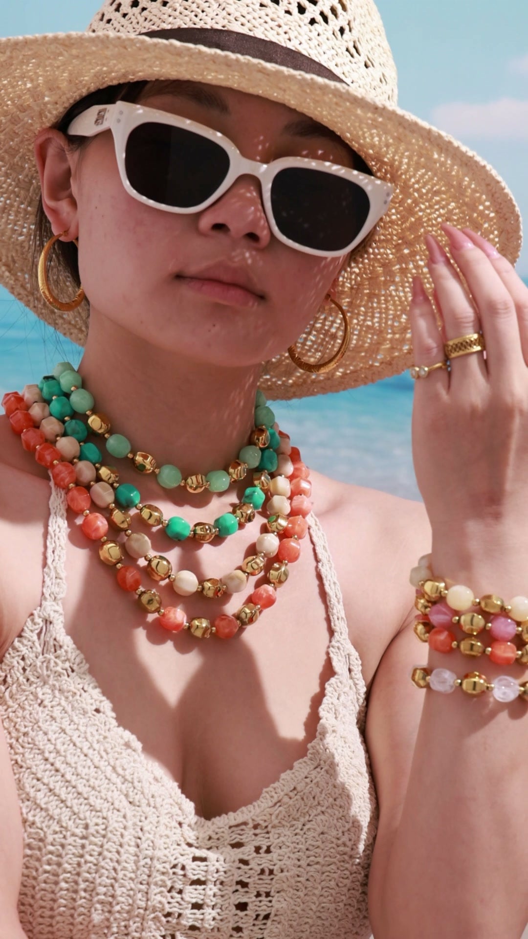 Video of a model wearing layered colorful resin bead necklaces and stacked matching bracelets with a bold resort-inspired styling look.