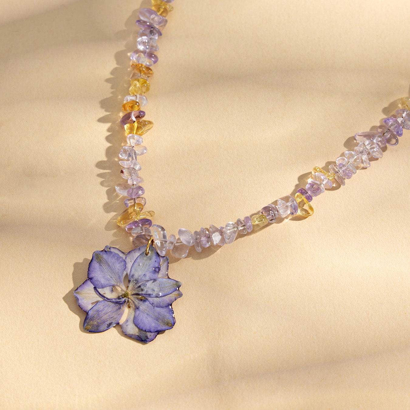 Close-up of purple resin flower pendant necklace with crystal bead chain for botanical jewelry displays