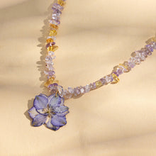 Close-up of purple resin flower pendant necklace with crystal bead chain for botanical jewelry displays