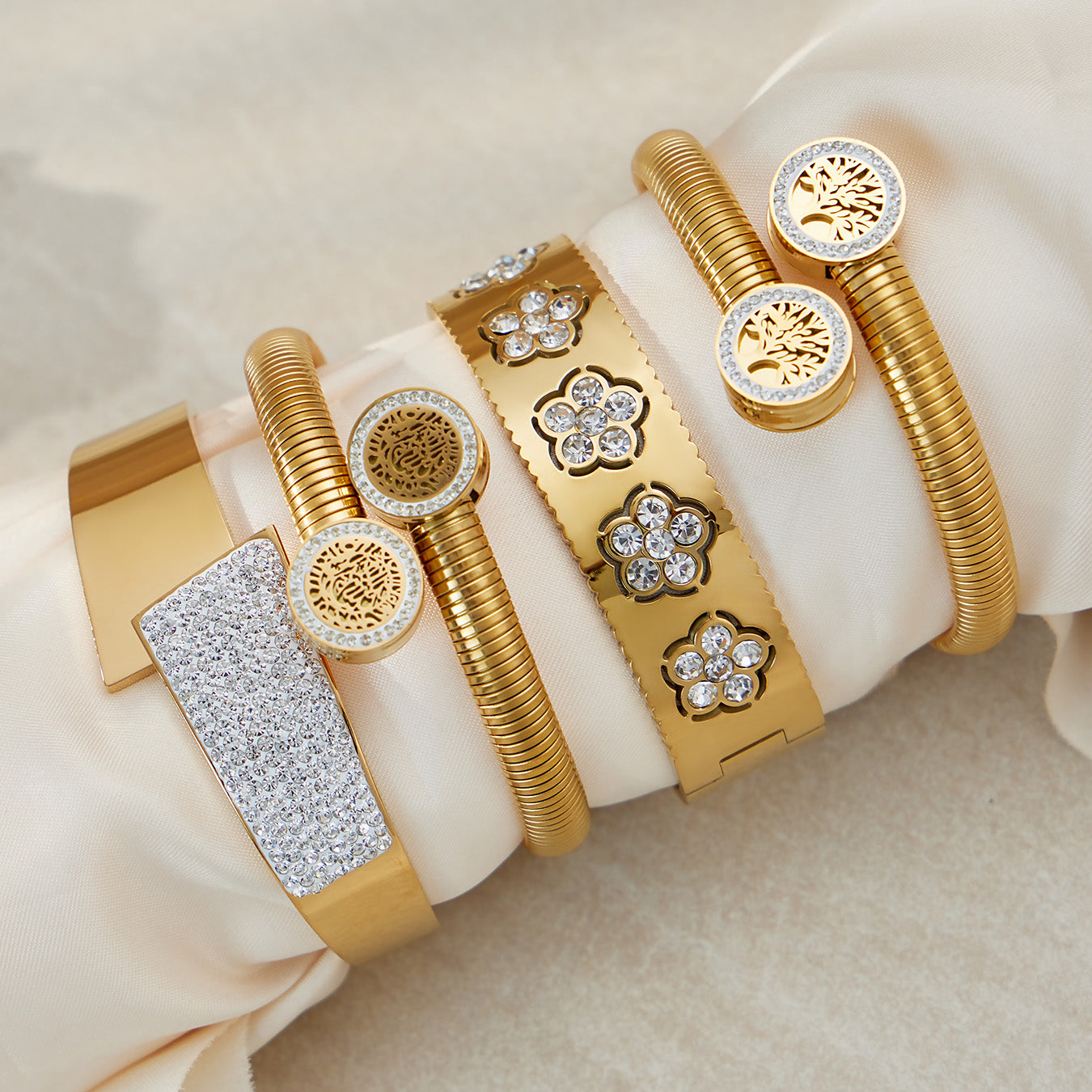 PVD gold plated zircon flower open bangle set styled on fabric: elegant lightweight design