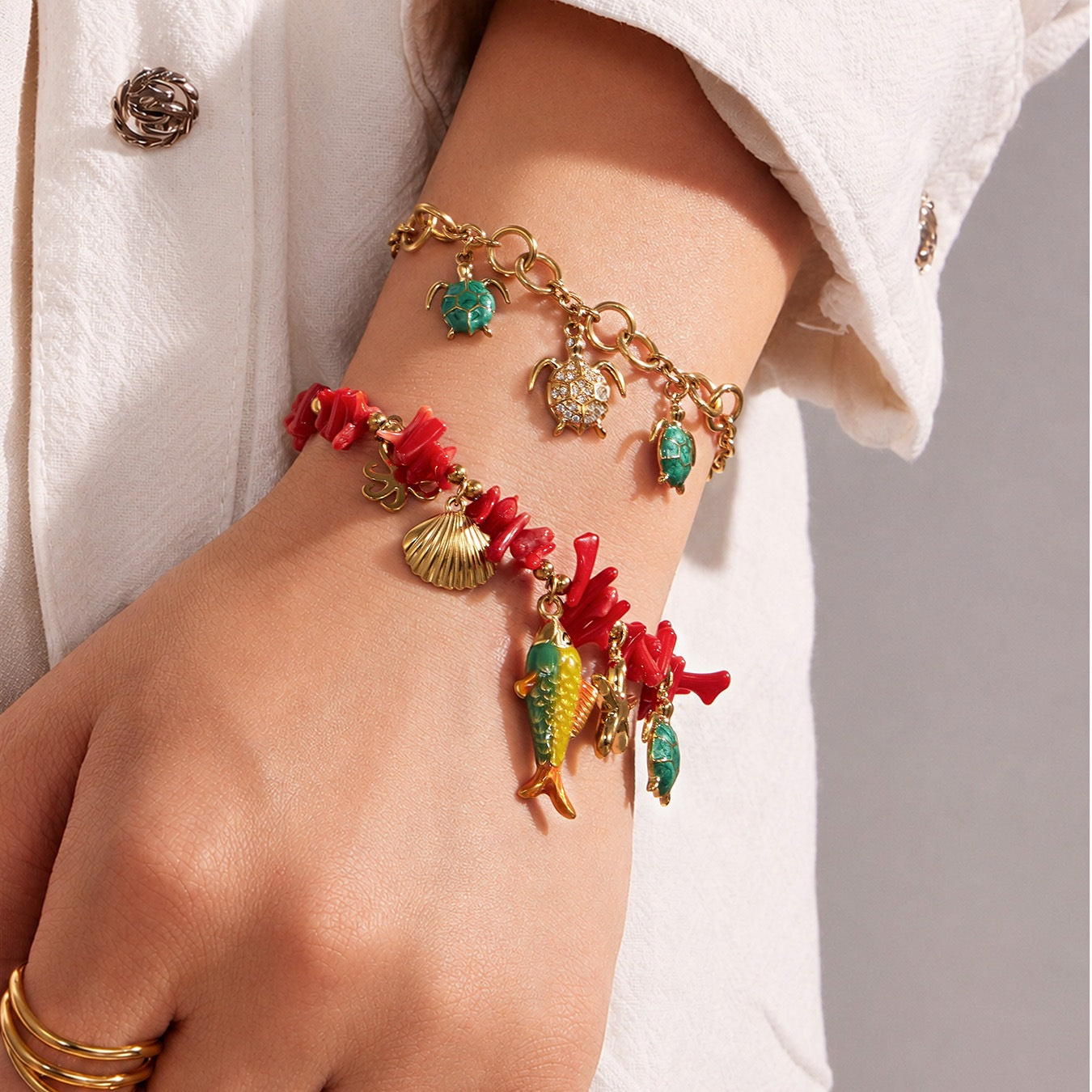 
Red coral-inspired ocean animal charm bracelet worn on wrist with turtle and shell pendants for beach jewelry collections