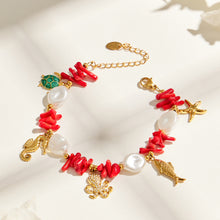 Ocean animal charm bracelet with red coral-style beads and gold-tone details