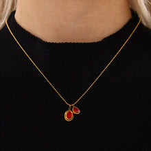Model wearing a red double zircon drop necklace with a black top