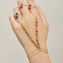 Red and multicolor cubic zirconia hand chain bracelets in gold tone worn across the back of the hand