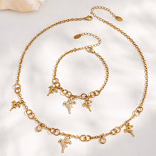 Gold reindeer necklace and bracelet arranged together in a circular flat lay