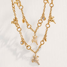 Close-up of gold reindeer necklace charms and clear zircon details on a light background