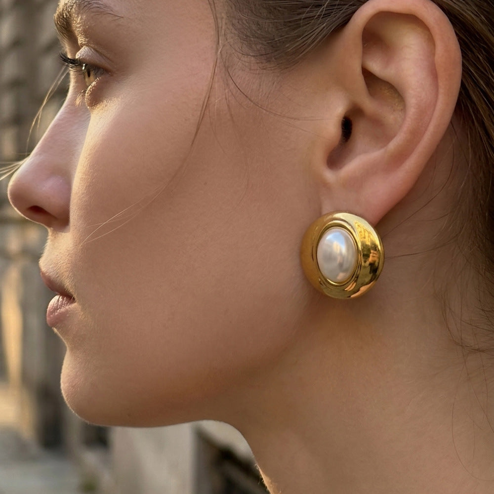 Side view of gold resin dome stud earrings worn on the earlobe