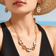 Close-up of a model wearing a resin mariner link necklace and matching drop earrings