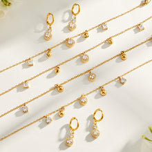 Gold tone stainless steel round and square zircon jewelry detail flat lay