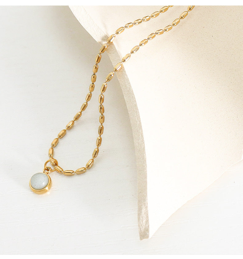 Round natural stone pendant necklace with delicate gold stainless steel chain displayed on a light background
