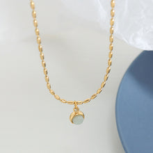 Round natural stone pendant necklace with polished gold stainless steel chain displayed on a clean background