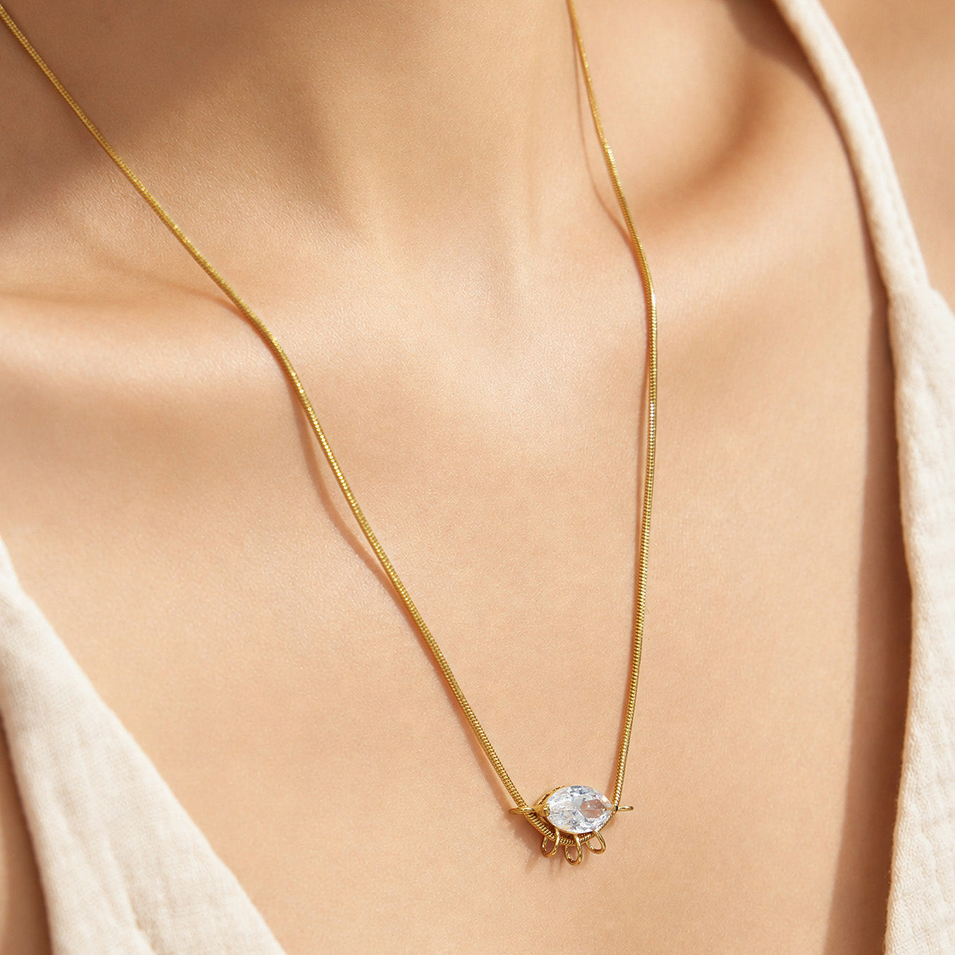Model wearing a round zircon pendant necklace with a minimalist gold-tone chain