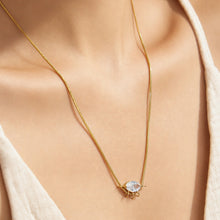Model wearing a round zircon pendant necklace with a minimalist gold-tone chain