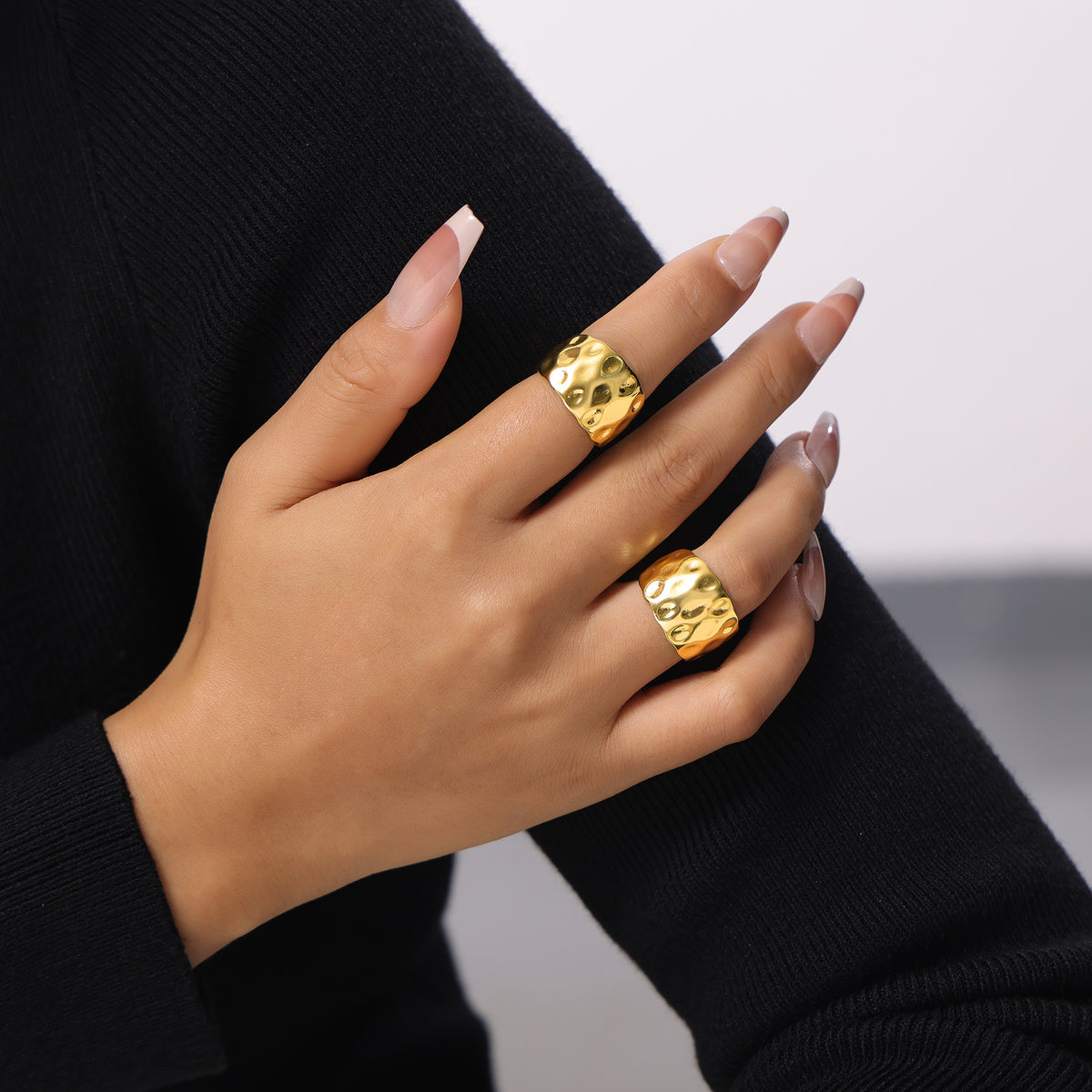 Sculptural gold open ring with irregular hammered texture worn on model