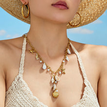 Seashell and starfish charm necklace close-up on model with gold-tone chain