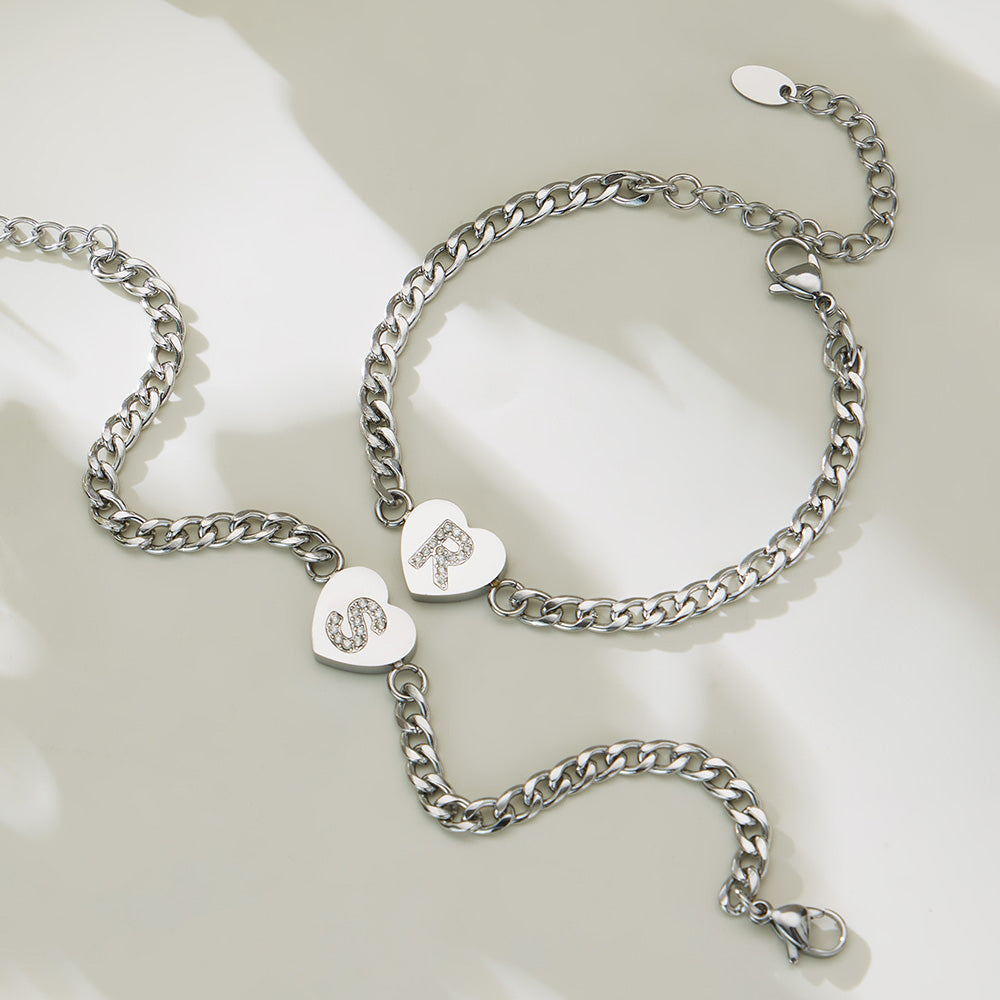 Silver-tone zircon initial heart necklace and bracelet matching set displayed on a neutral background