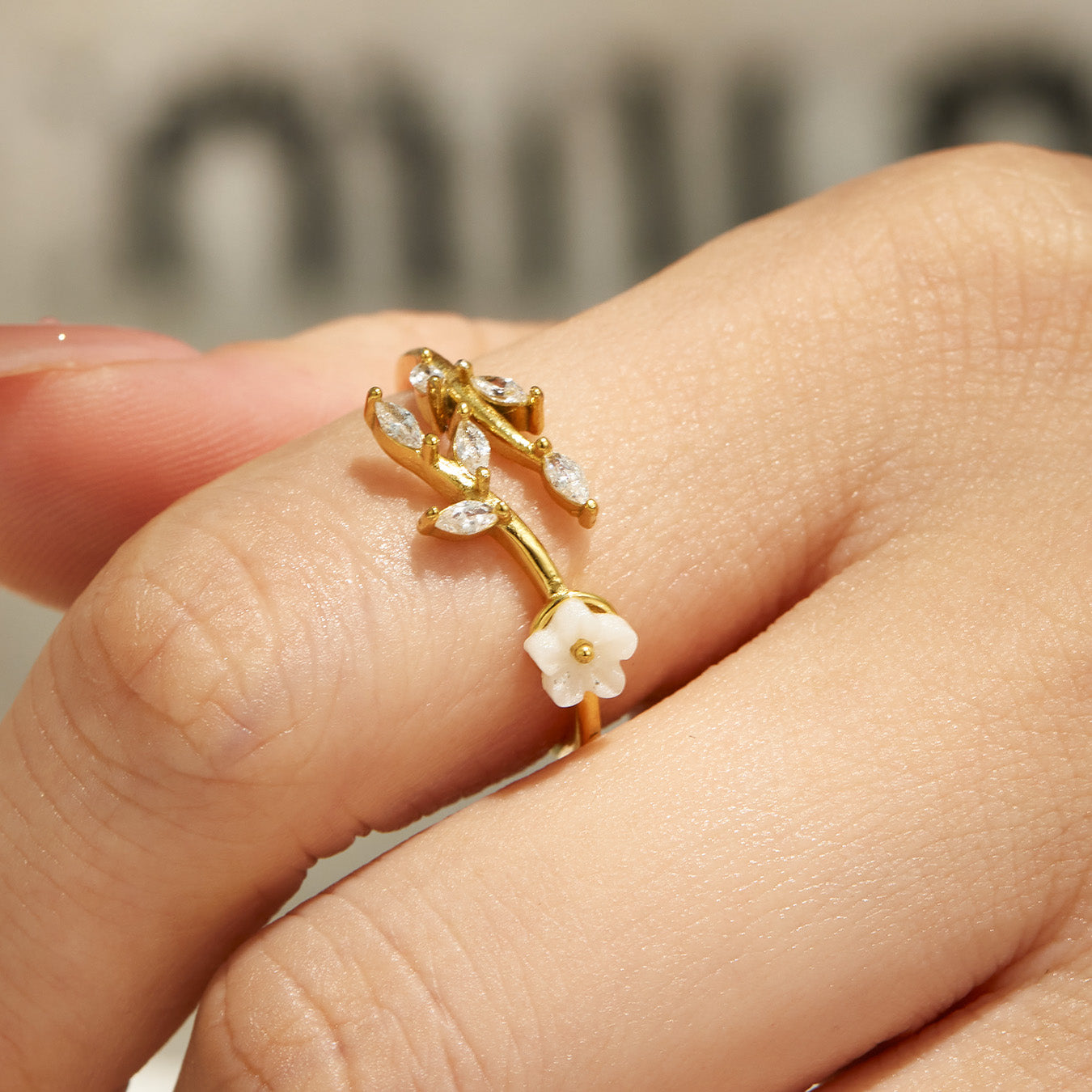 Single floral gold ring in 316L stainless steel worn on finger with a refined feminine jewelry look
