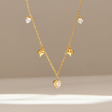 Delicate gold zircon charm necklace with central drop pendant displayed on neutral background