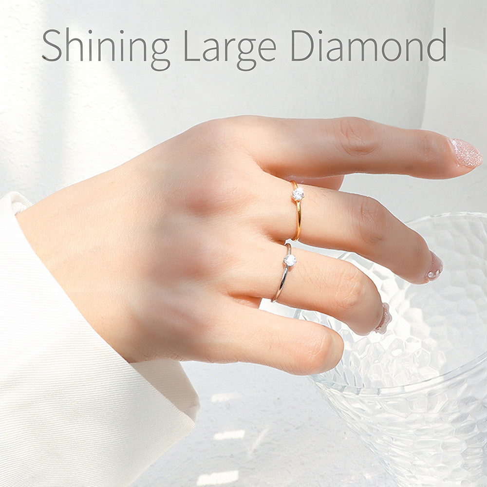 Minimalist solitaire stacking rings worn on hand with delicate round stone accents