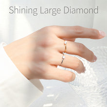 Minimalist solitaire stacking rings worn on hand with delicate round stone accents