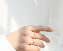 Dainty silver tone solitaire stacking ring styled on hand for everyday jewelry display