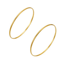 Two slim gold-tone stainless steel stackable bangles in smooth and textured finishes