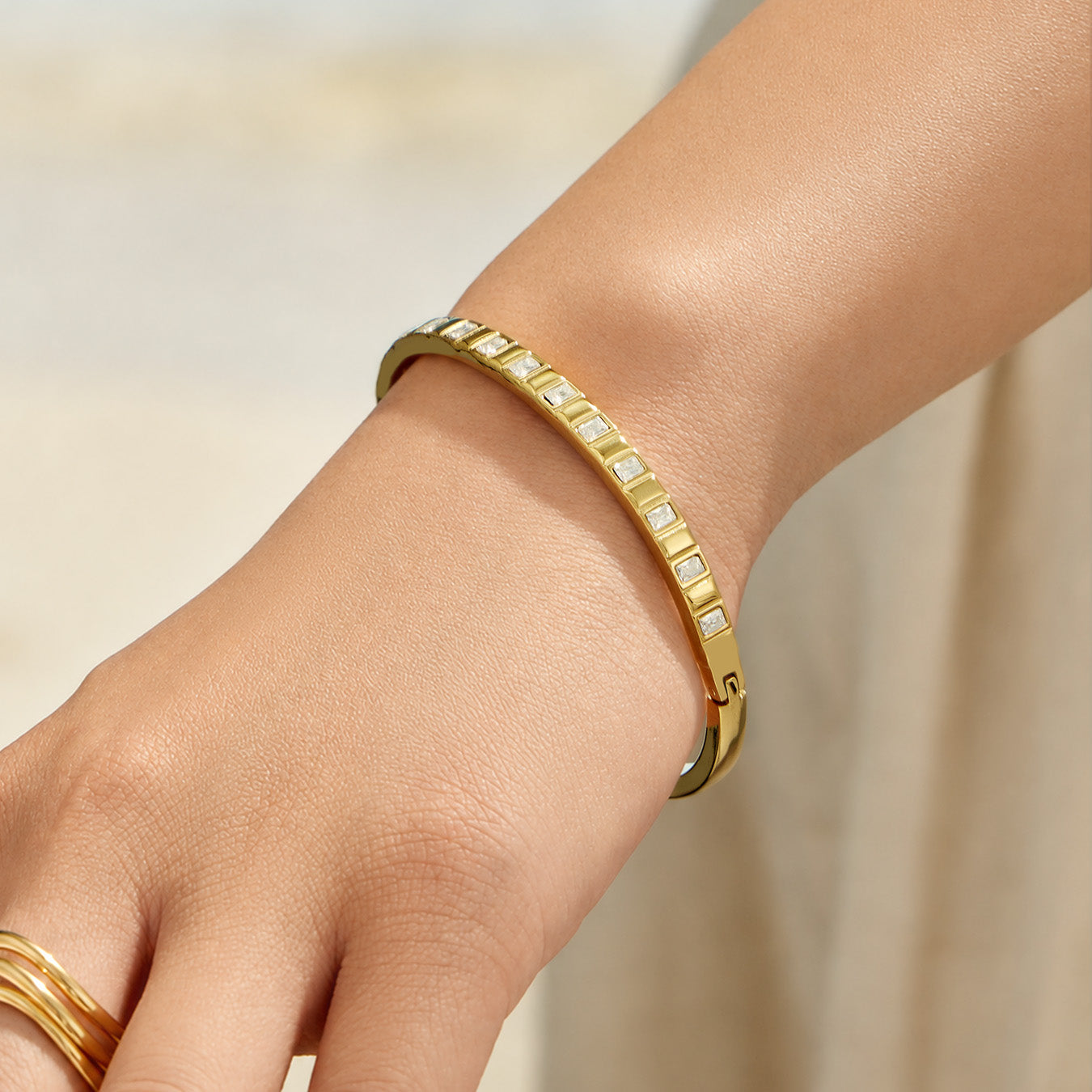 Model wearing a slim gold zircon bangle bracelet on the wrist