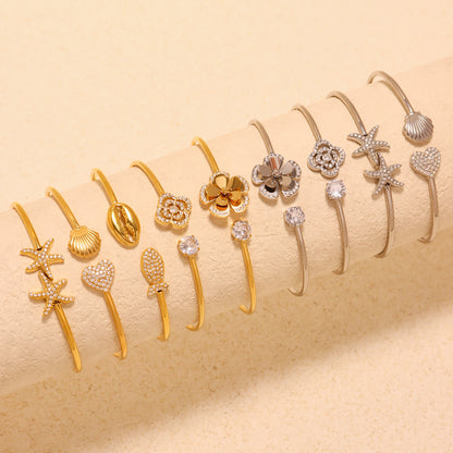 18K gold plated & silver sparkling zircon starfish flower shell thin open bangle set, displayed on fabric
