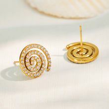 Spiral pavé cubic zirconia stud earrings in a styled flat lay