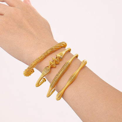 gold spiral texture bangle set, layered on model's wrist