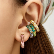 Model wearing stacked colorful cubic zirconia ear cuffs