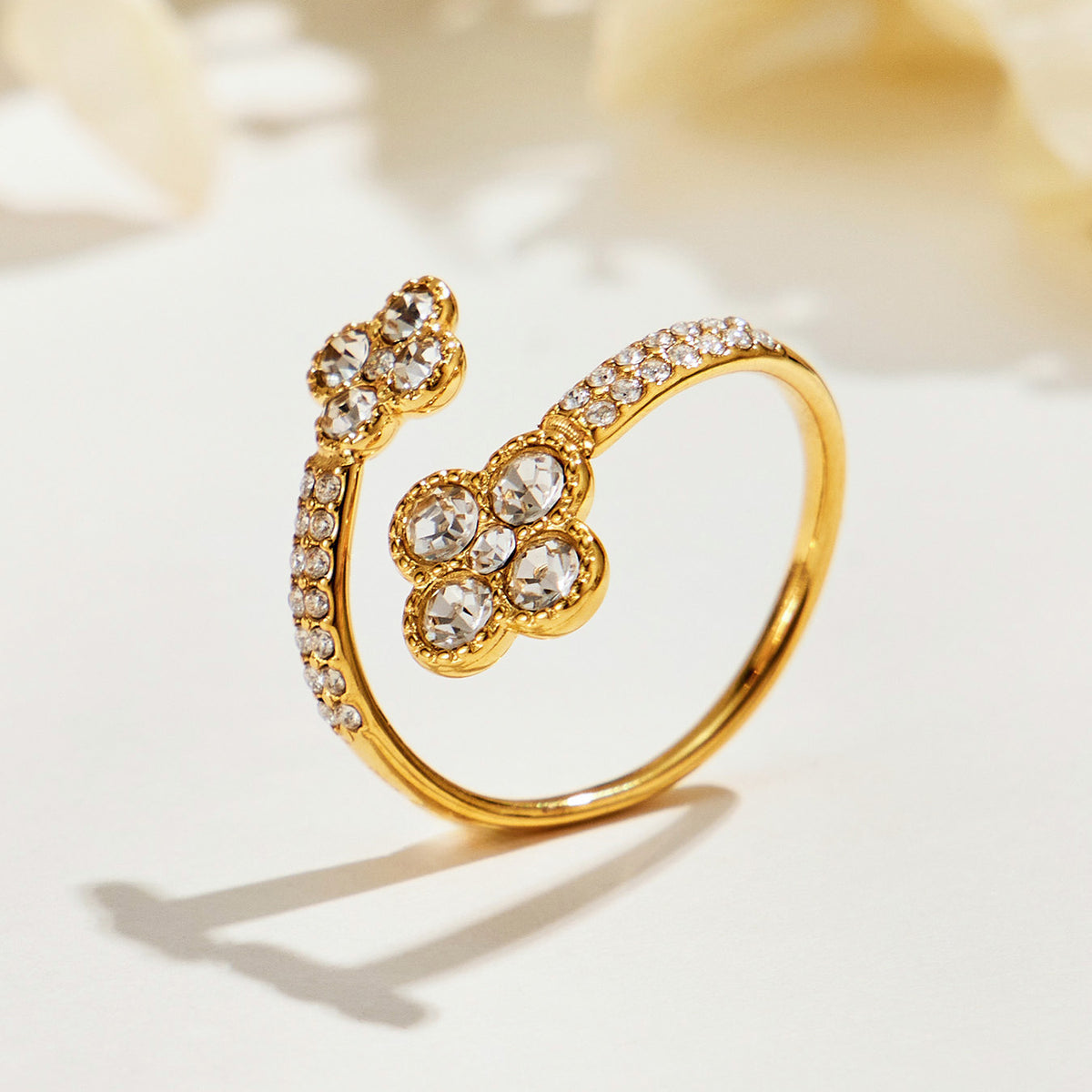 Side view of the A456 gold-tone double-flower open ring with clear-stone petals
