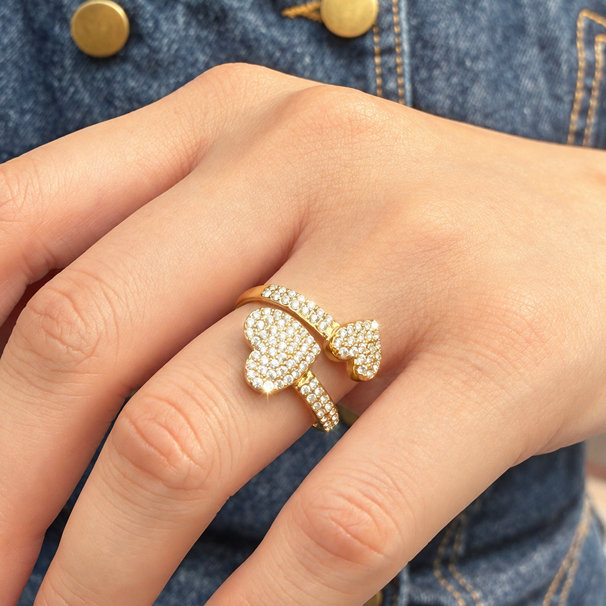 A457 gold-tone open ring worn on a finger with two pave-style heart motifs
