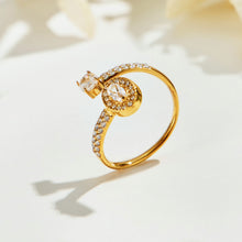 Side view of the A465 gold-tone two-stone open ring standing on a cream surface