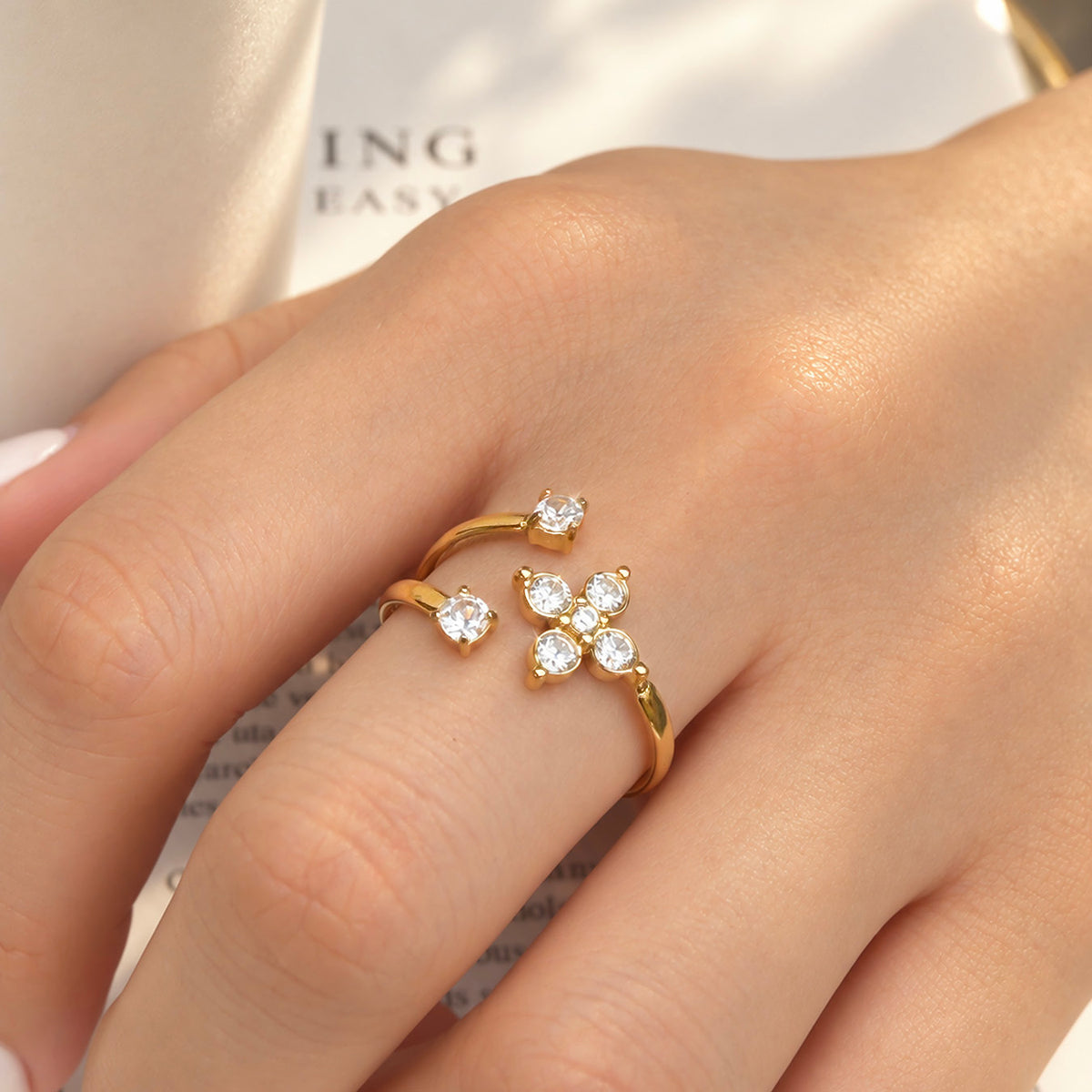 Close-up of the A471 gold-tone flower ring with clear stone petals and an open band