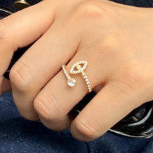 A709 gold-tone eye-shaped open ring worn on a finger, with a clear-stone outline and slim band