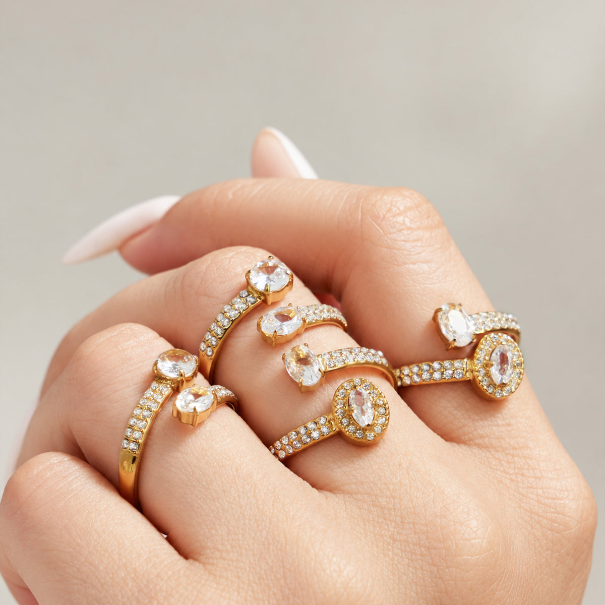 Stainless steel CZ rings in multiple open designs layered together on hand