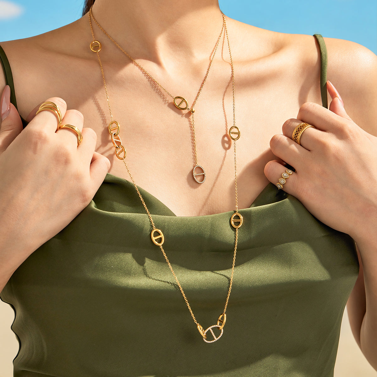 Model wearing a gold-tone stainless steel geometric link Y necklace with drop detail
