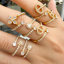 Multiple gold-tone stainless steel open rings styled across overlapping hands, showing different decorative motifs