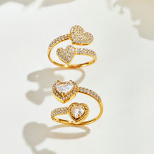 Gold-tone pave-heart and double-heart halo rings displayed together, showing their different stone details