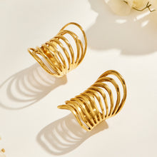 Angled view of two gold-tone stainless steel rings showing elongated profiles and graduated curved bands