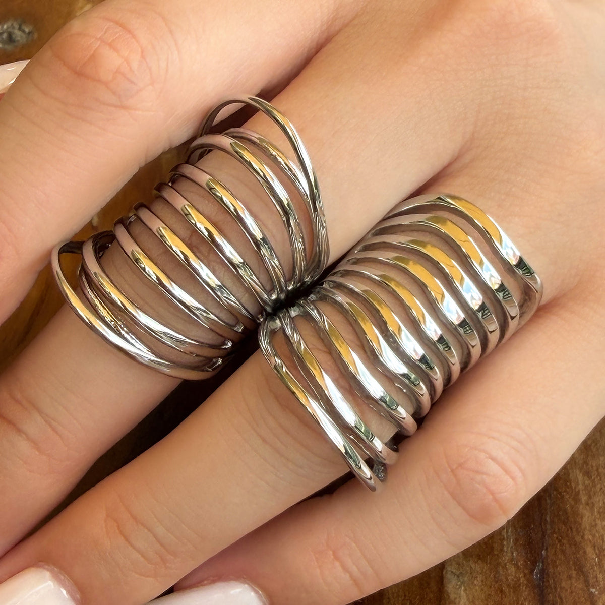 Two silver-tone stainless steel multi-band statement rings worn on adjacent fingers