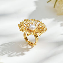 Side view of a gold-tone stainless steel openwork flower ring with a white faux pearl center