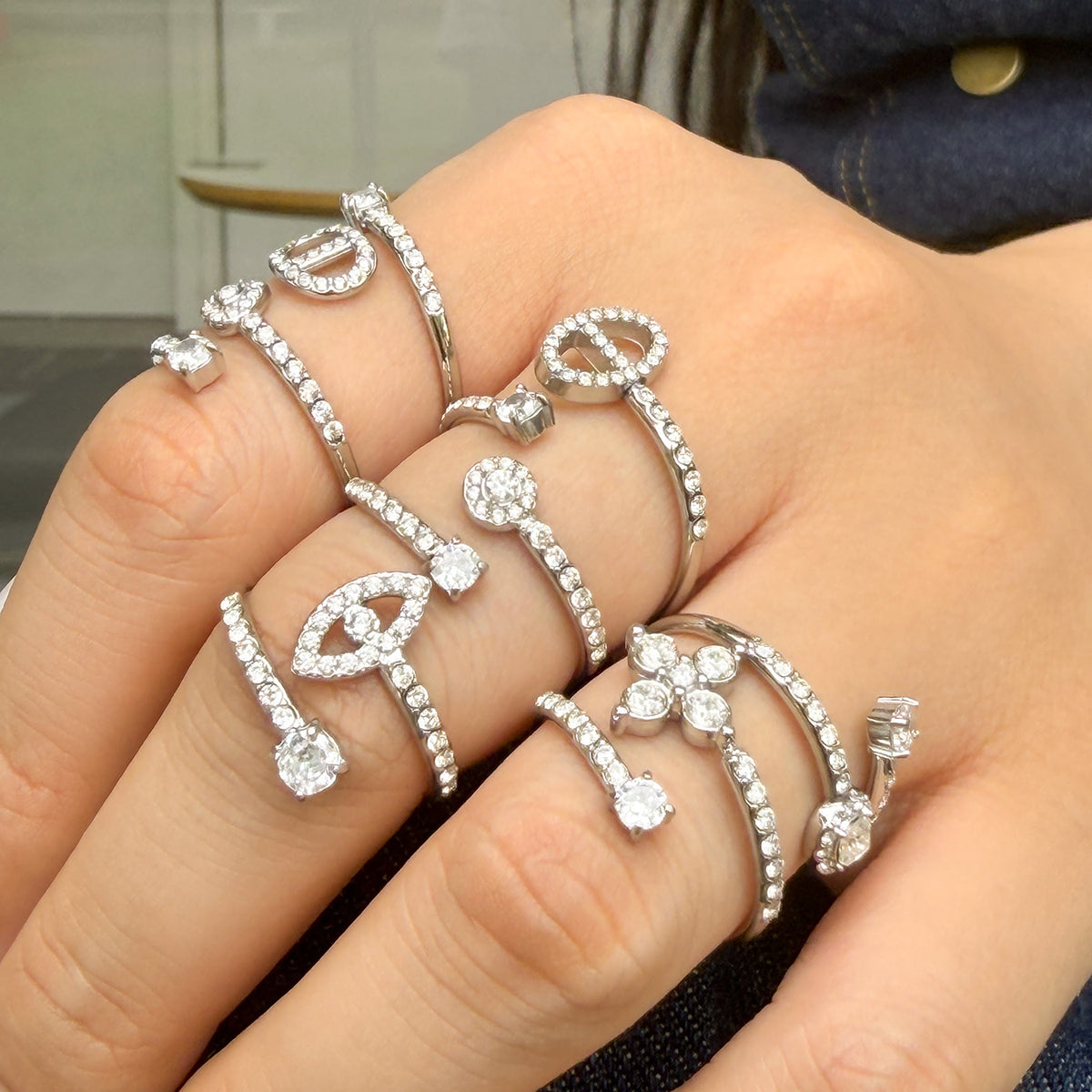 Steel-tone stainless steel heart, flower and geometric open rings styled across fingers