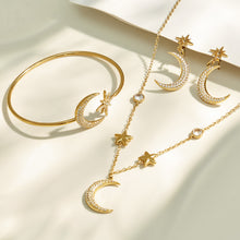 Gold star and moon necklace and cuff bracelet arranged together in a flat lay