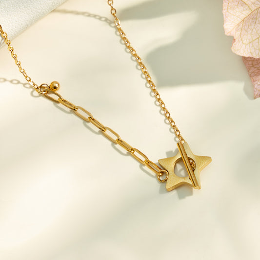 Close-up detail of a gold star T-bar necklace in stainless steel
