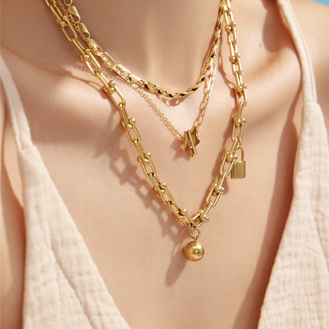 Model wearing a layered gold star T-bar necklace with a minimalist V-neck outfit