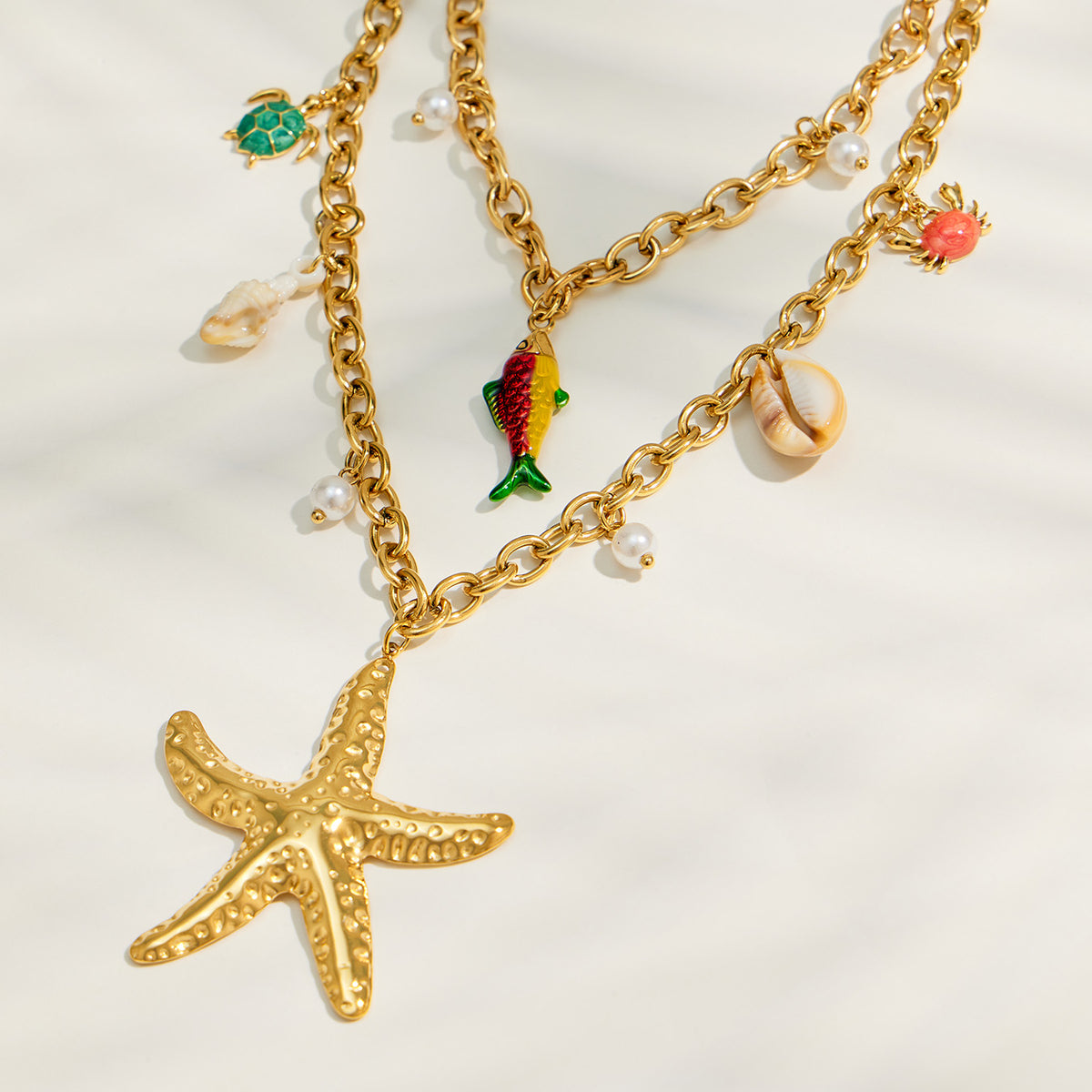 Starfish, shell and fish charm necklace with gold chain and faux pearl accents