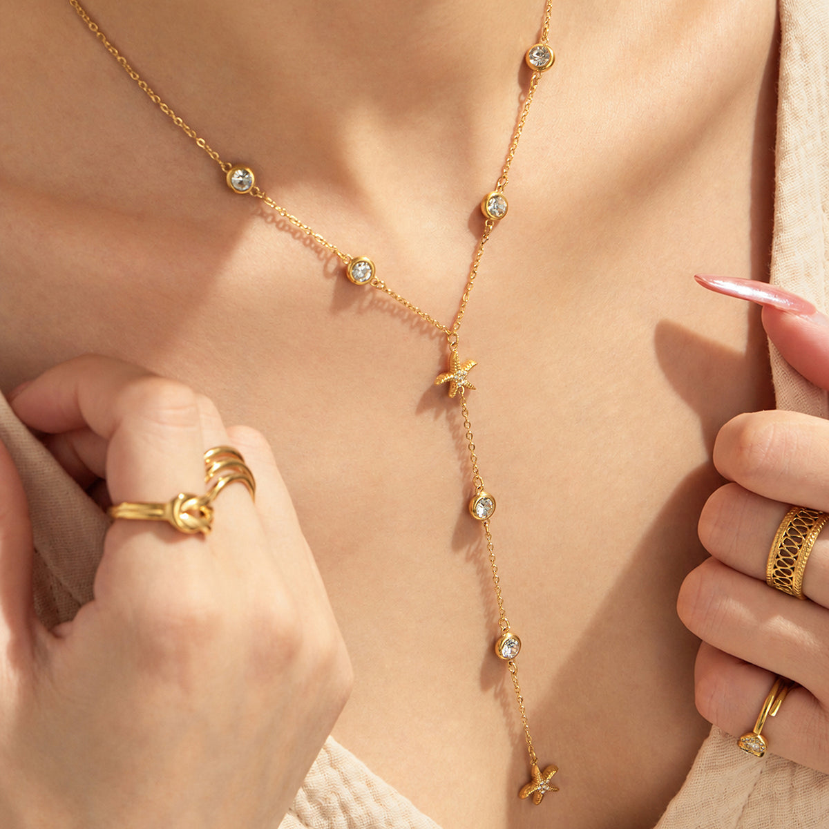 Close-up of starfish zircon Y necklace worn at the neckline on model
